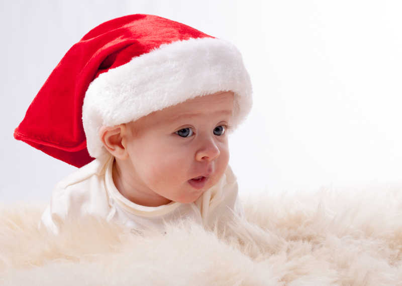 毛毯上戴着圣诞帽的可爱孩子