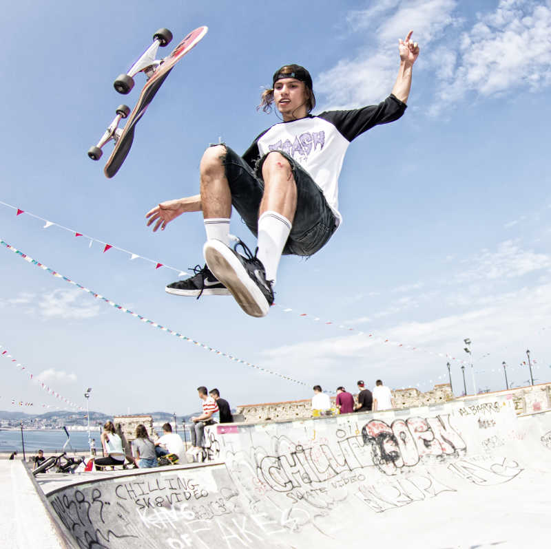 玩滑板跳跃的年轻外国男子