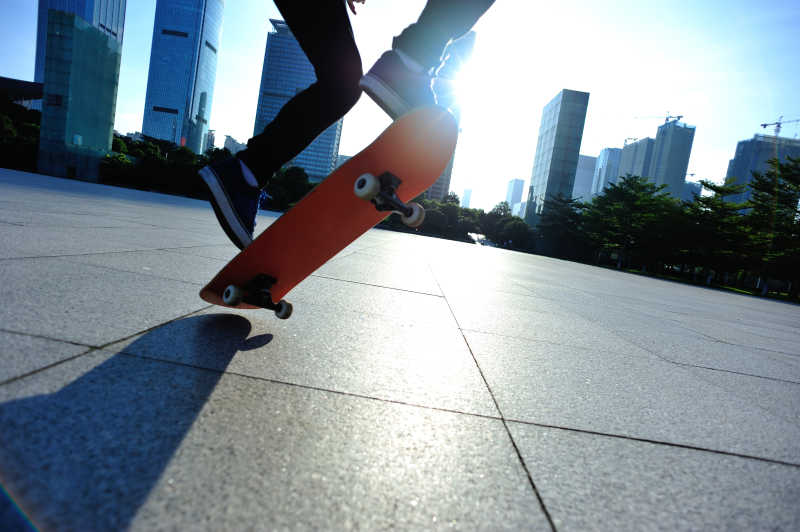 阳光下在城市街头玩滑板的年轻人