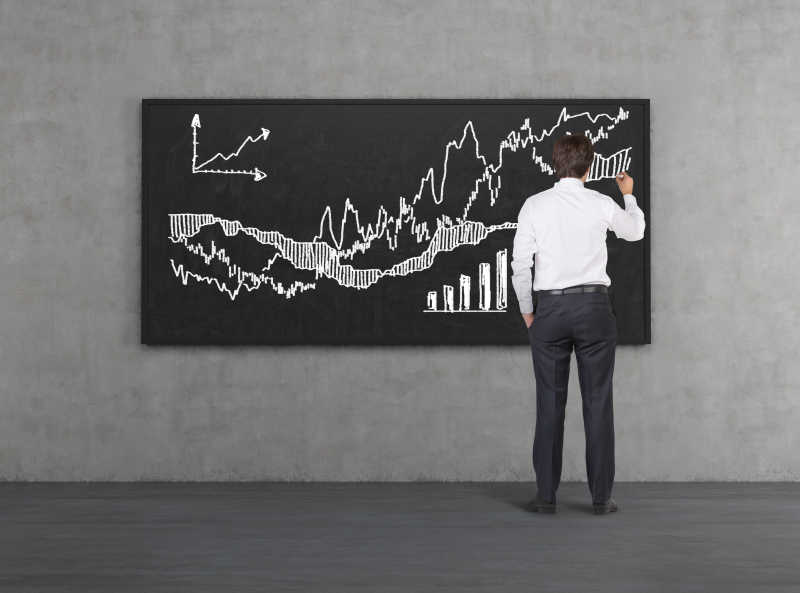 一个商人在黑板上画股市走向趋势图表