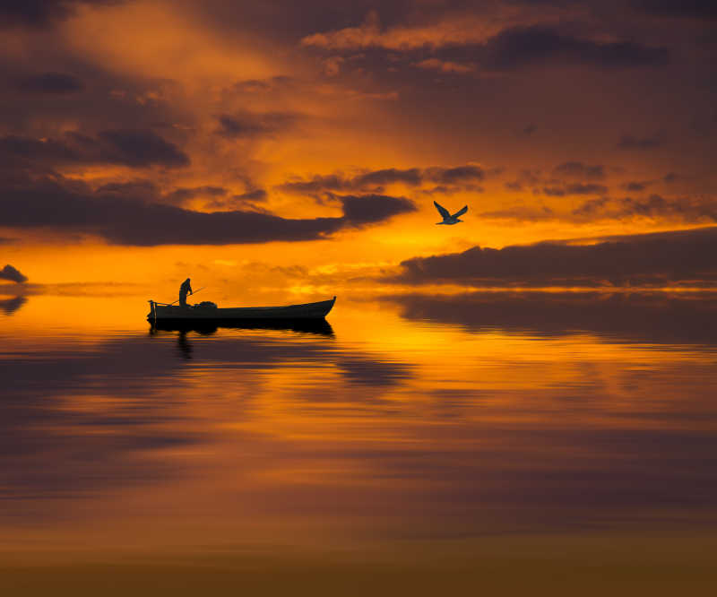 日落时分在海上渔船上的渔者