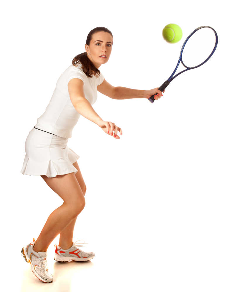 白色背景下认真打网球的女运动员