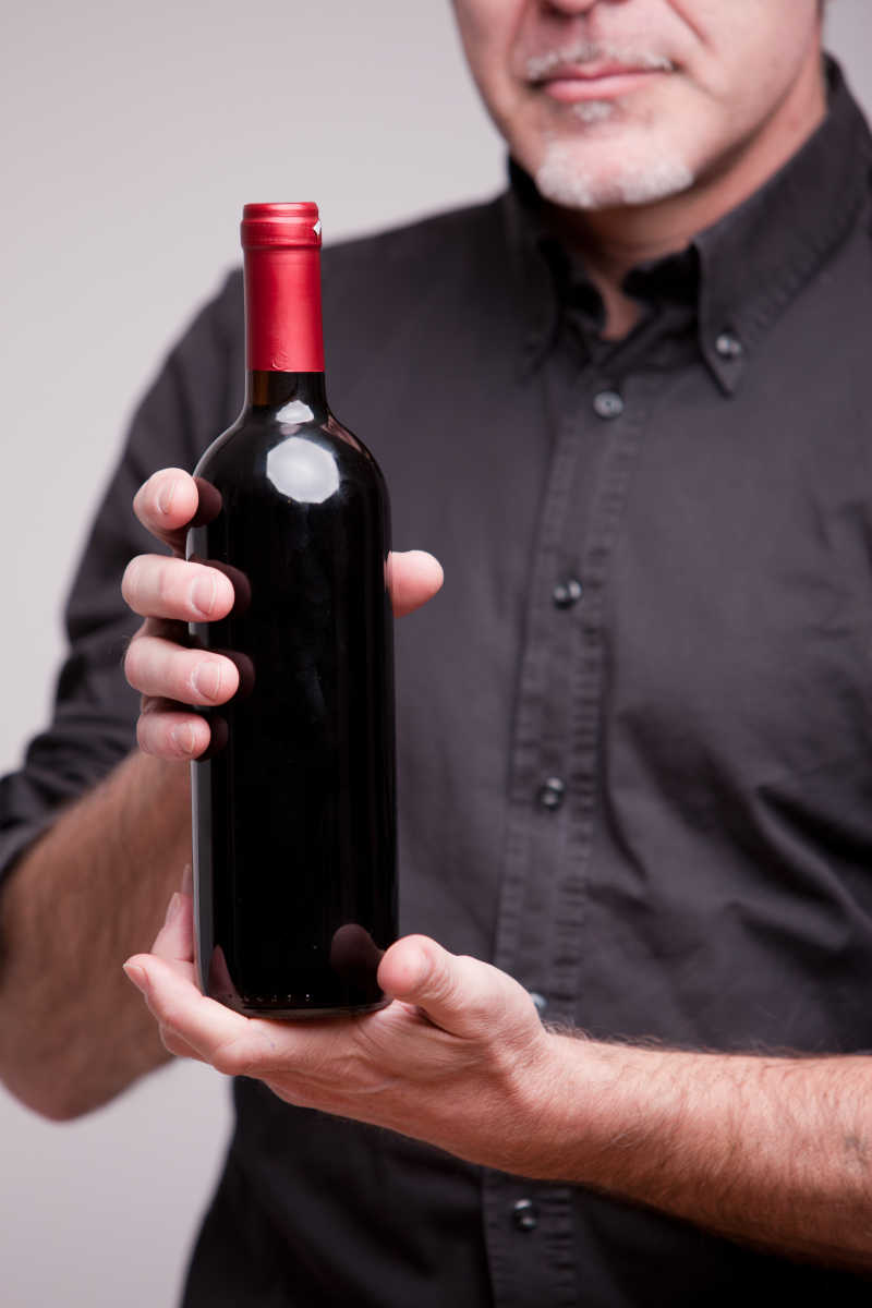 展示一瓶红葡萄酒的高级专家