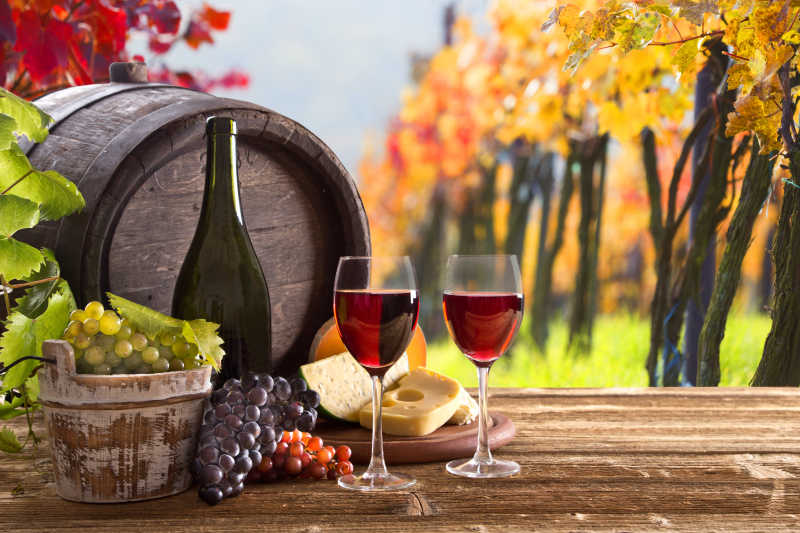 木桌上的酒瓶和酒杯和葡萄