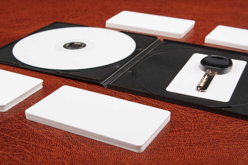 红色桌面上的白色光盘和名片模板