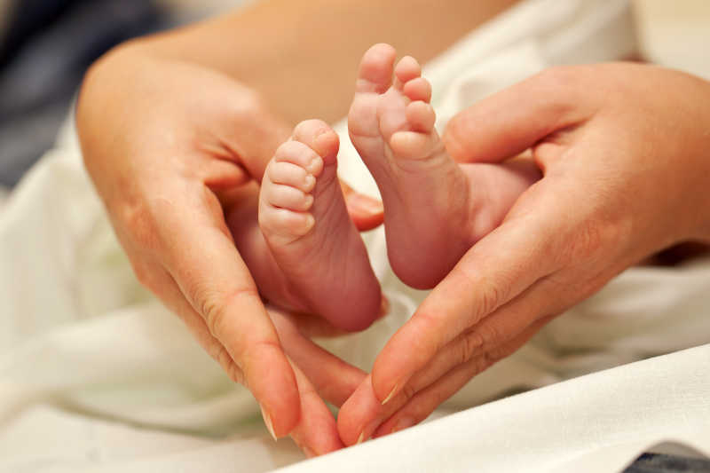 妈妈的手与婴儿的脚形成心形