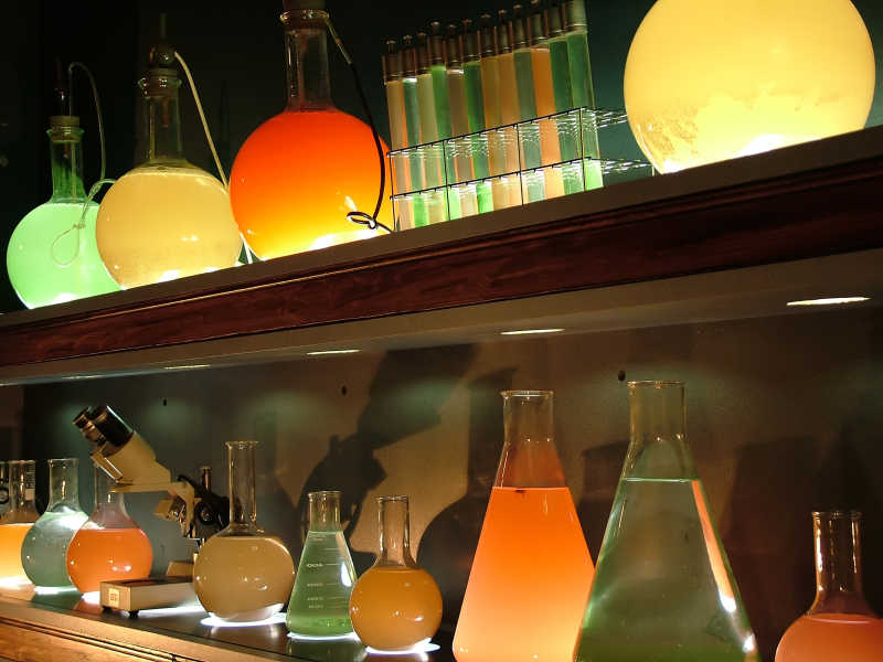架子上有各种装有液体的化学玻璃器皿