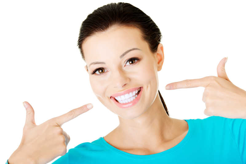 女人指着自己洁白的牙齿微笑