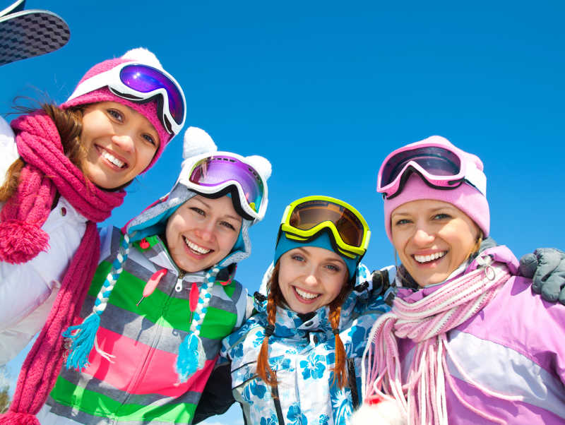 四个穿着滑雪服的年轻女孩开心大笑