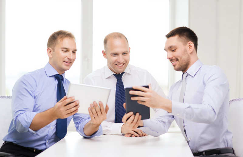 三位商人使用平板电脑进行讨论