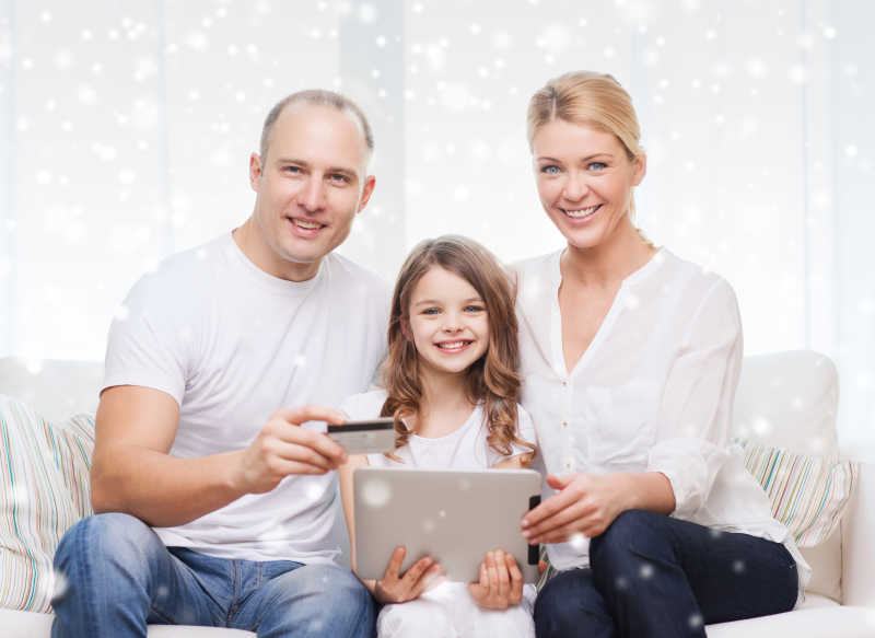 幸福的家庭在使用平板电脑和信用卡
