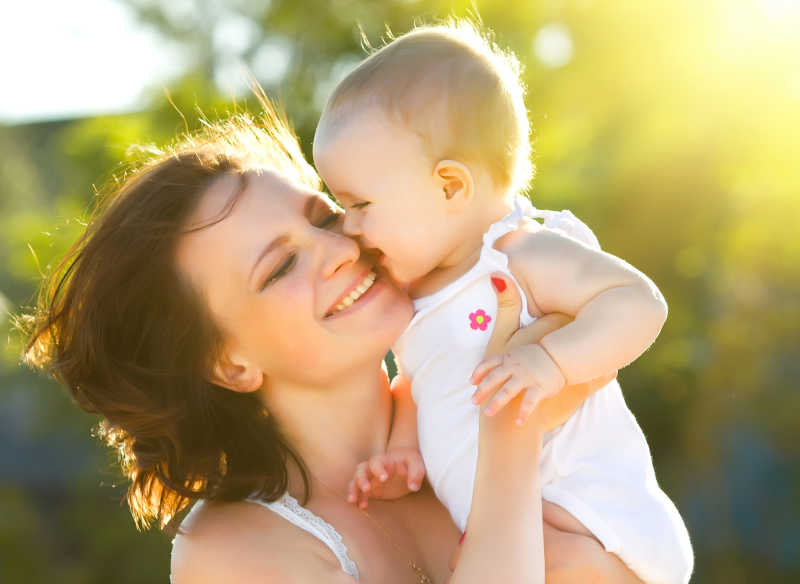 快乐的妈妈和女儿在大自然中微笑