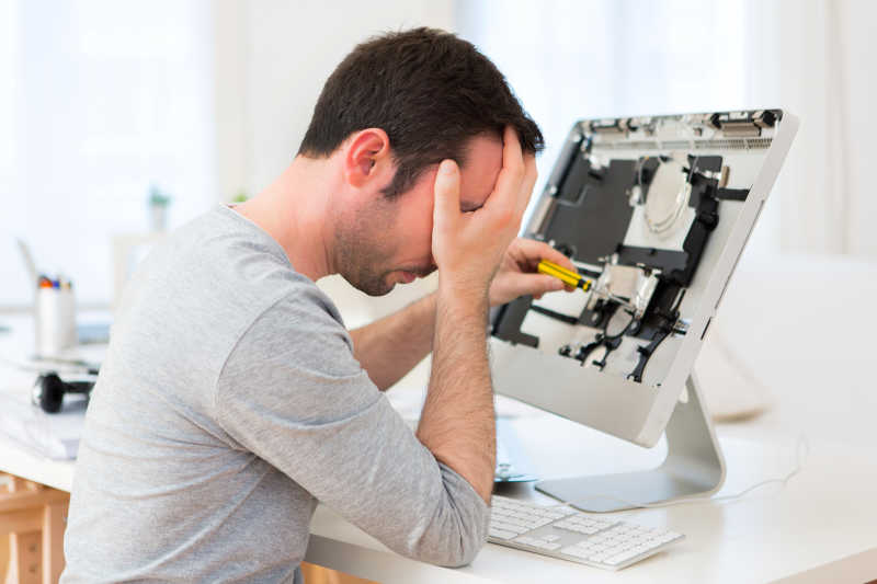 一位年轻貌美的男子试图修理电脑