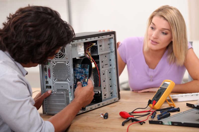 女人看着男人正在修计算机