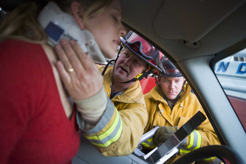 消防员帮助一名车上受伤的妇女