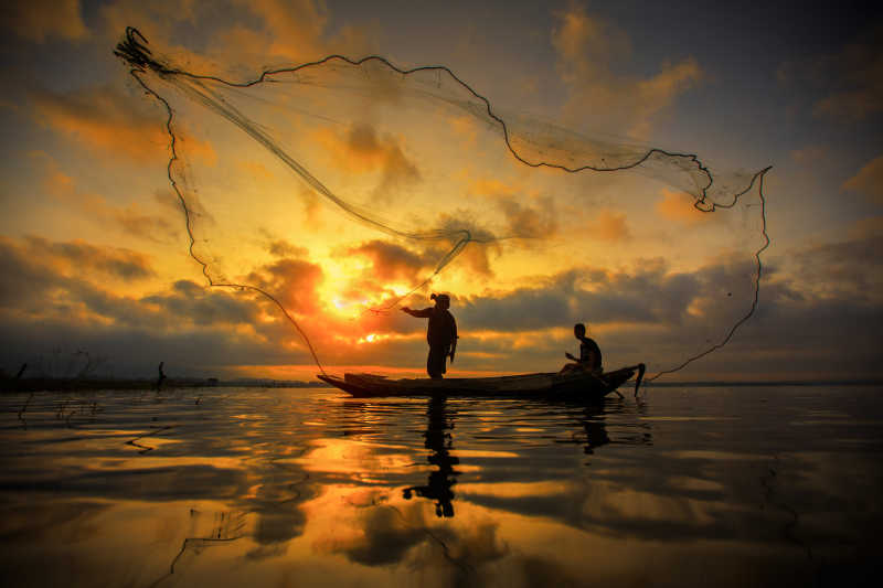 渔民在行走的船上钓鱼