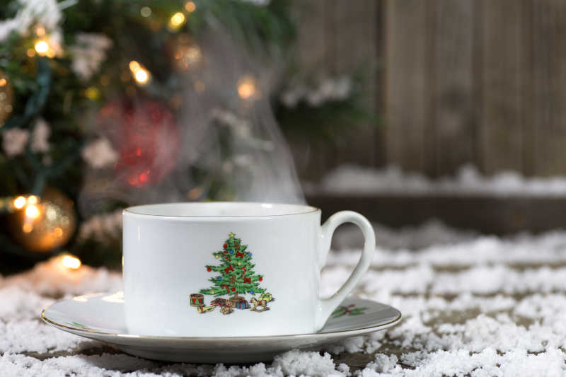 有背景装饰的雪甲板上的圣诞咖啡杯