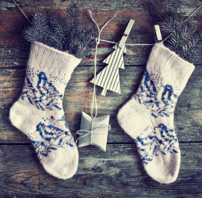 在木制背景上圣诞礼品和冷杉搭配袜子 