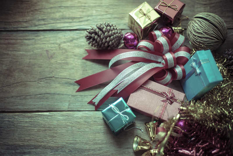木色桌面上圣诞节的礼物盒蝴蝶结等装饰品