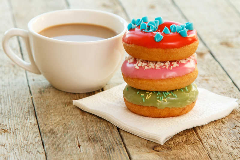 咖啡和丰富多彩的甜甜圈放在桌子上