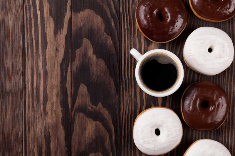 木制餐桌上的甜甜圈和咖啡