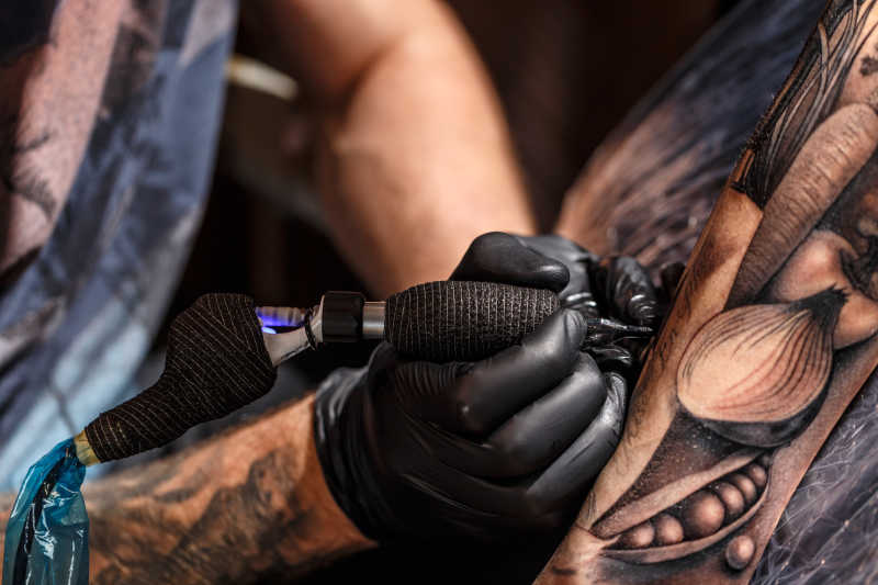 纹身师在手臂上操作纹身过程