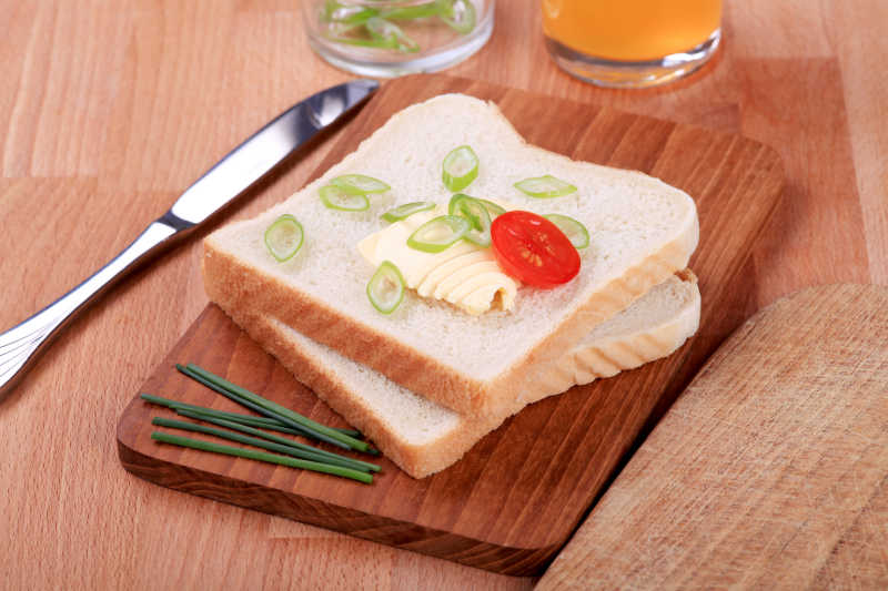 切片的面包上的黄油和葱花特写