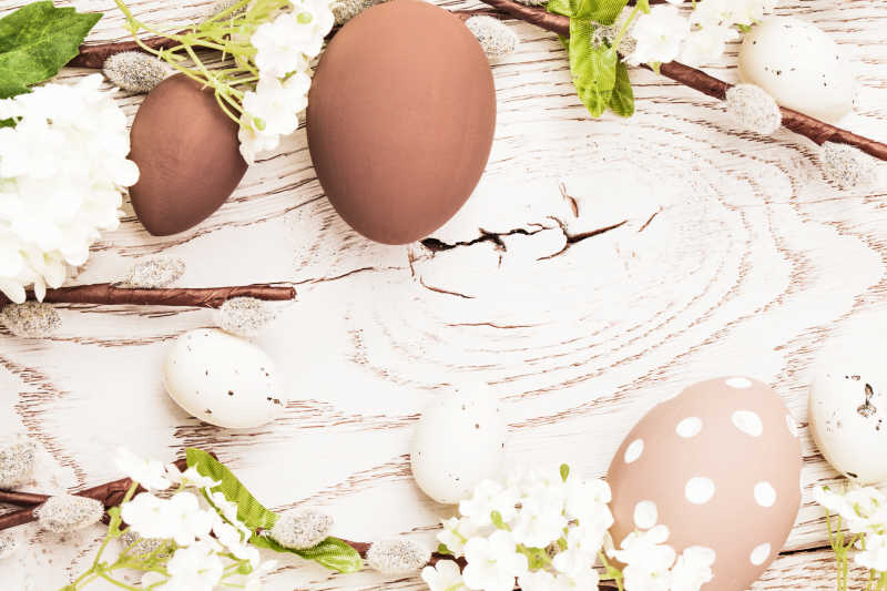 木制背景中有鲜花装饰的复活节彩蛋