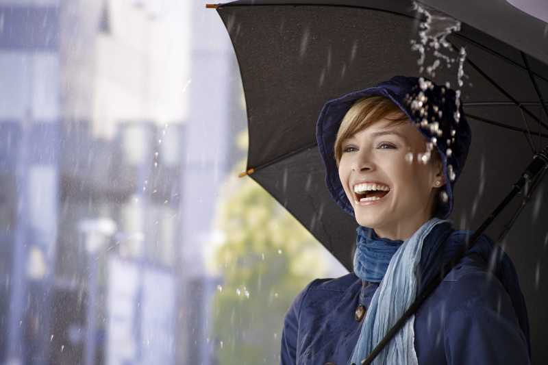 雨中伞下幸福的年轻女子