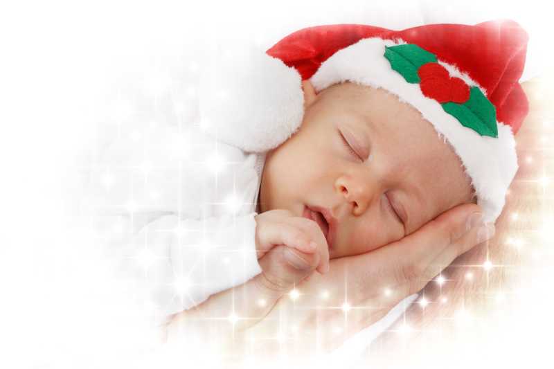 妈妈手心里戴着圣诞帽睡着的小婴儿