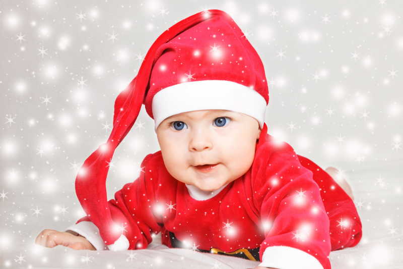 雪地里戴着圣诞帽的小婴儿