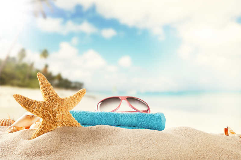 沙滩上的眼镜海星和毛巾