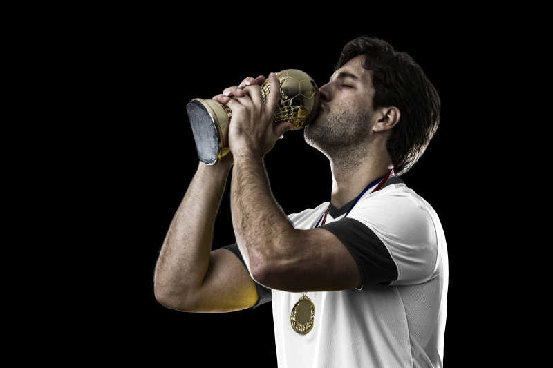 德国足球运动员手里拿着奖杯庆祝冠军