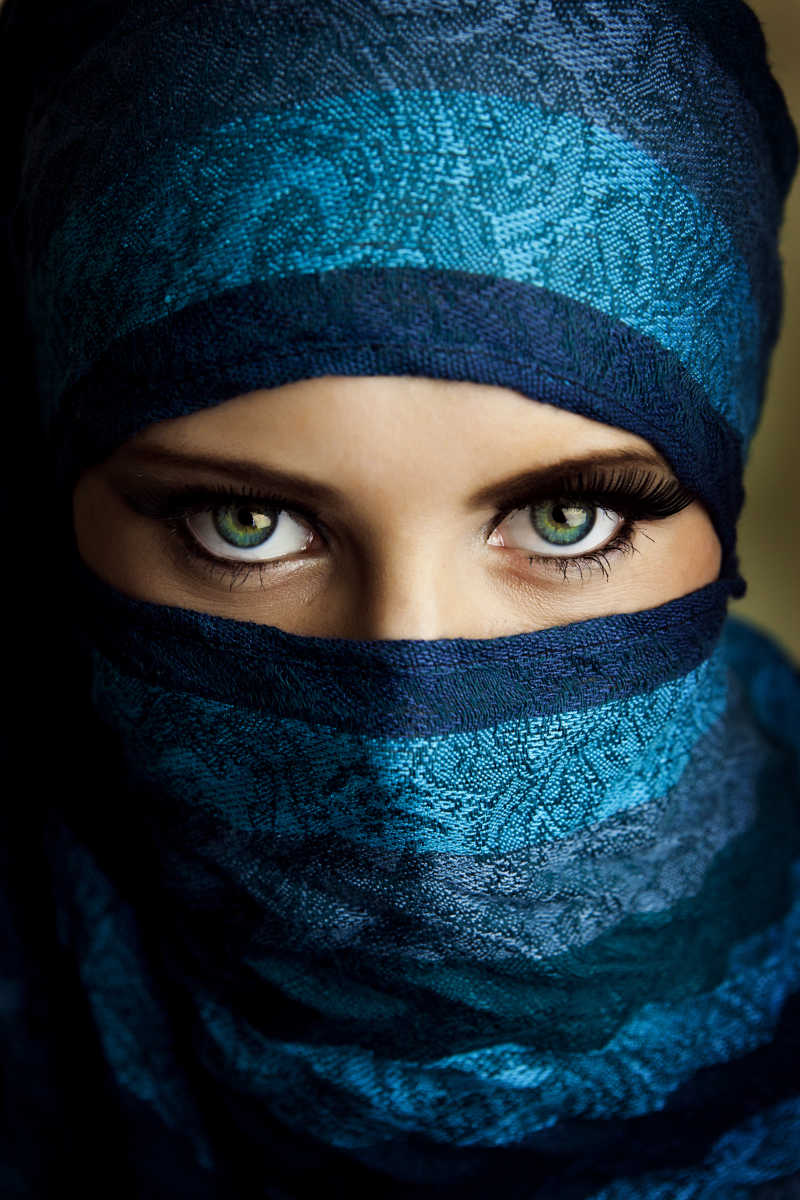 带着蓝色头巾面纱的性感的蓝眼睛的年轻女人