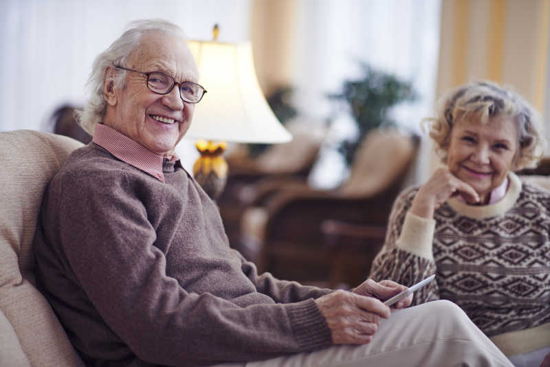 坐在沙发上微笑的老年夫妇