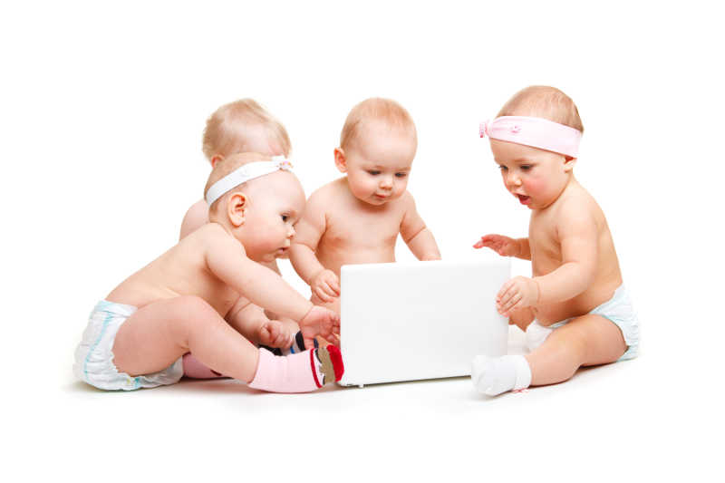 白色背景下几个婴儿好奇的在观看笔记本电脑