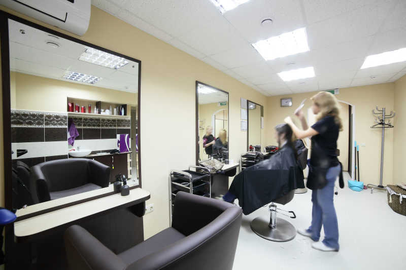 沙龙内美发师正在给一个顾客理发