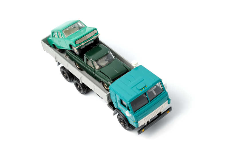 白色背景下玩具卡车后部的玩具车