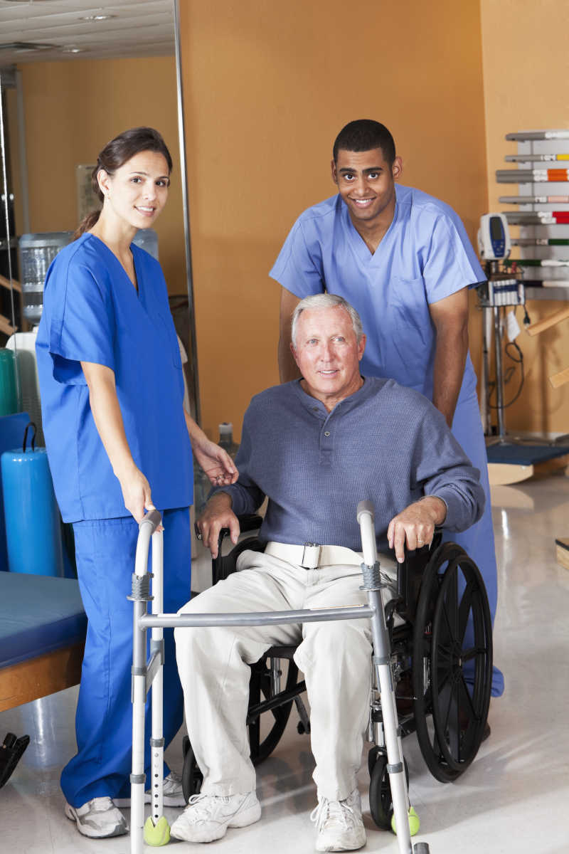 医院里医护人员在推着坐着轮椅的老人