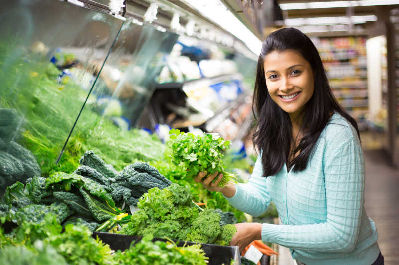 女人正在超市选新鲜的蔬菜