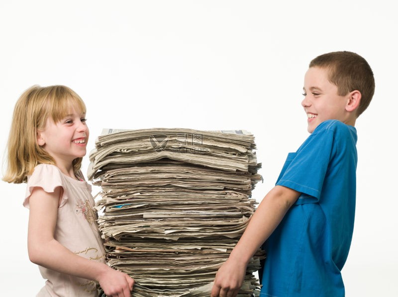 两个小孩在搬一摞厚厚的报纸