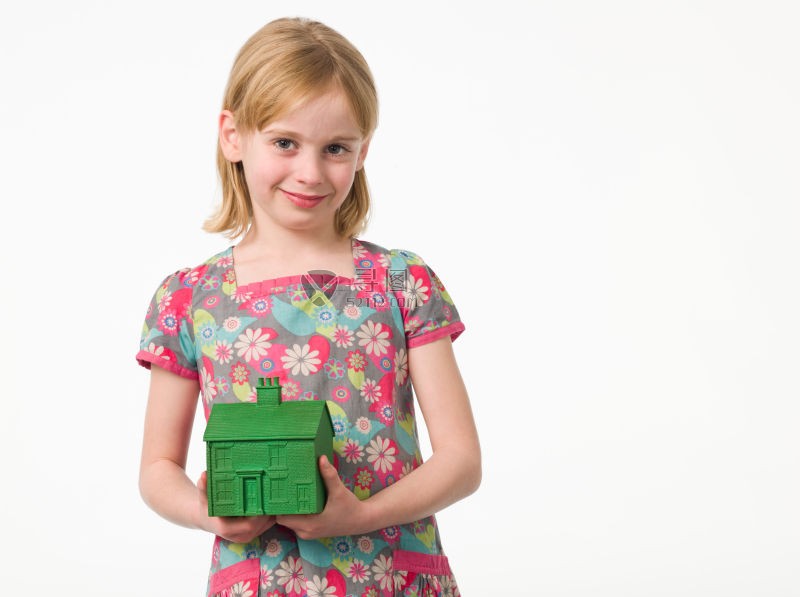 金发小女孩拿着一个绿色房子模型