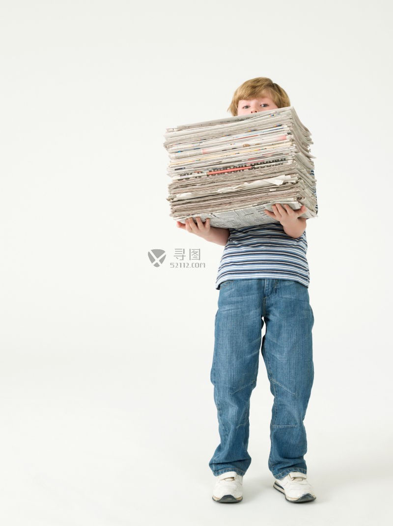 吃力的举起一摞报纸的小男孩
