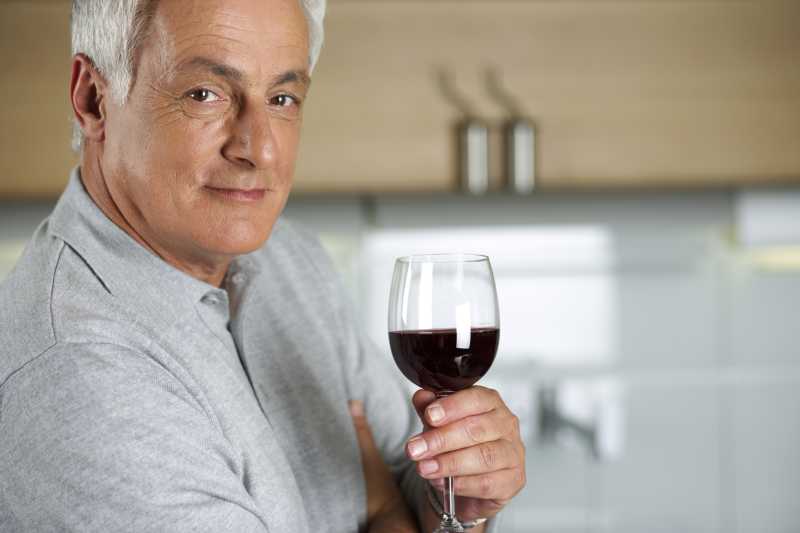 悠闲的喝着红酒的中年男性