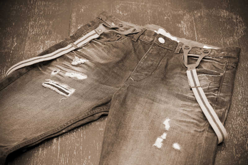 复古色调下的有洞的牛仔裤和吊带