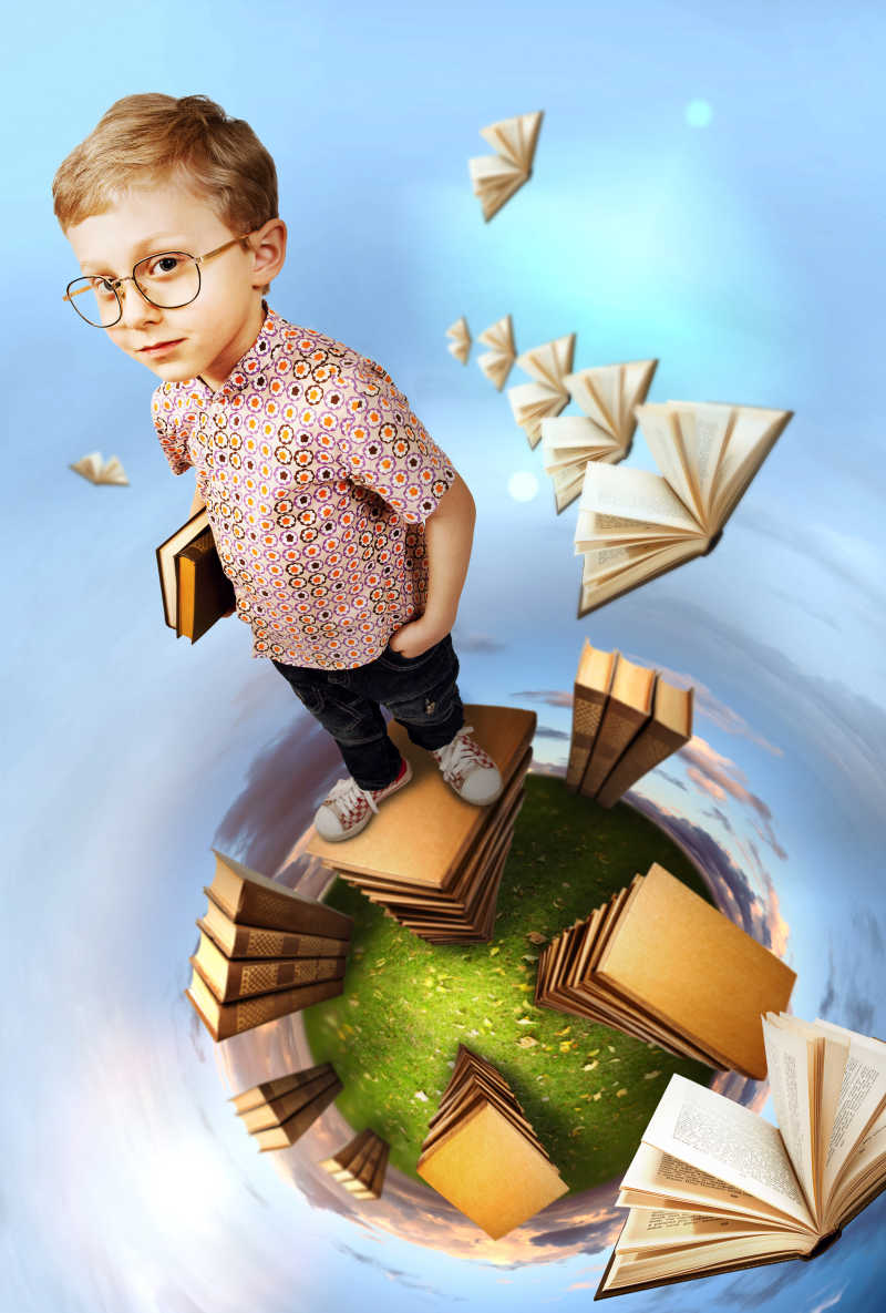 站在绿色星球上的一堆书上的聪明男孩