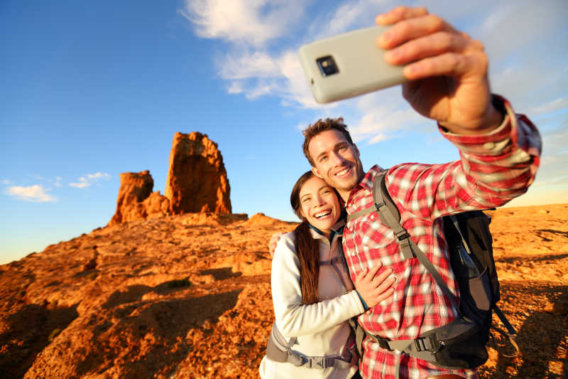 幸福的夫妇户外山顶上用手机自拍
