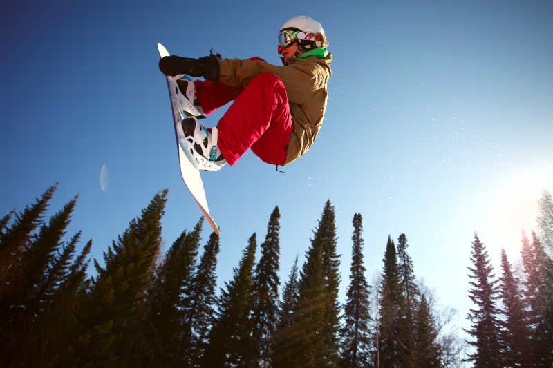 滑雪跳跃通过空气背景中的深蓝色的天空