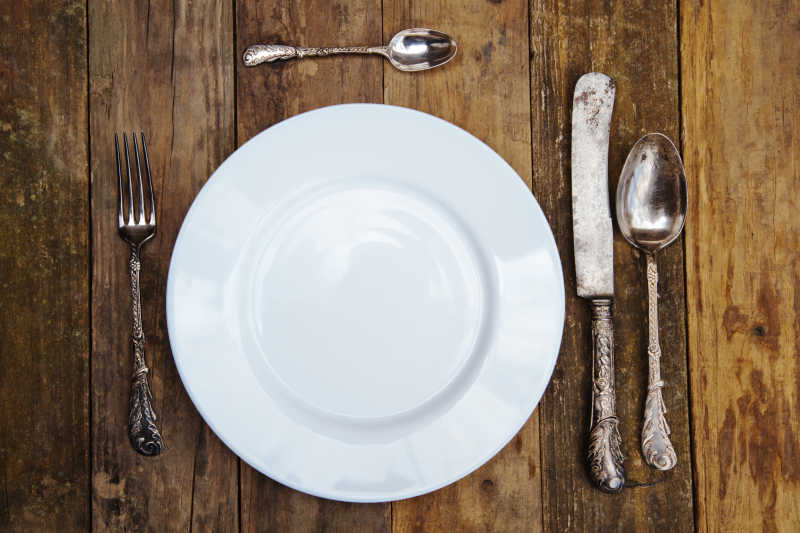 旧木桌上的盘子和餐具