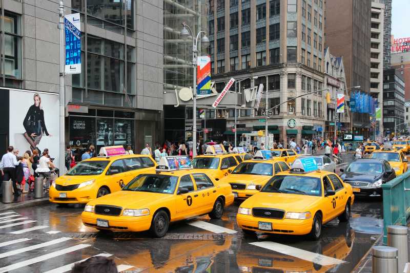 人们在纽约的第八大道乘坐黄色出租车
